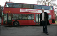 Richard Dawkins stands by the bus ad