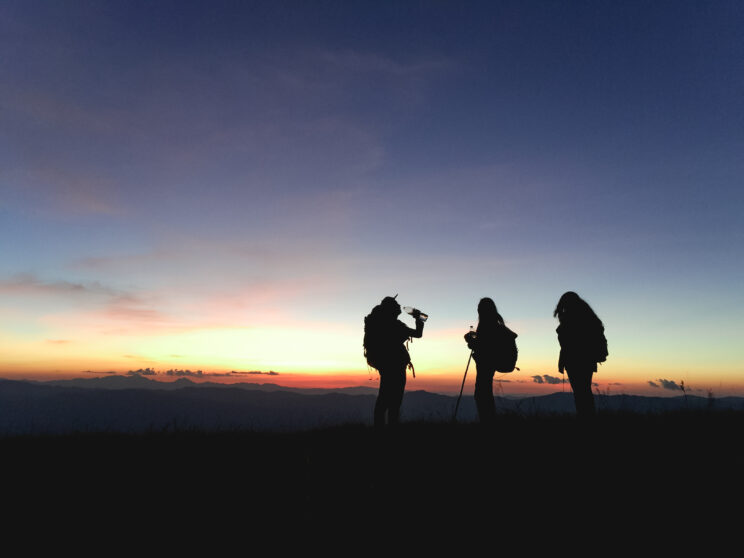 3 Hikers Silhouetted by Sunrise