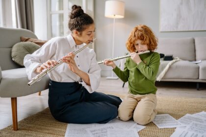 a boy learning how the play the flute from his mentor